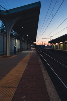 A beautiful railway station in the rays of a colorful sunset. Taking a picture using a wide-angle lens. High quality photo