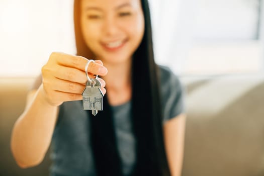 A woman's hand proudly holds a house key symbolizing homeownership and achievement. Reflecting confidence happiness and the excitement of buying a new house.