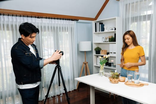 Asian beautiful woman food specialist presenting healthy meal wholegrain bun bread basket on live channel recorded video camera by smart cameraman streaming lifestyle social media online. Infobahn.