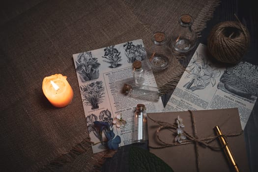 Mystical still life in vintage style with empty flasks, burning candles, letters and newspaper clippings. High quality photo