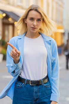 Displeased upset Caucasian woman reacting to unpleasant awful idea, dissatisfied with bad quality, wave hand, shake head No, dismiss idea, don't like proposal. Young adult lady traveler on city street