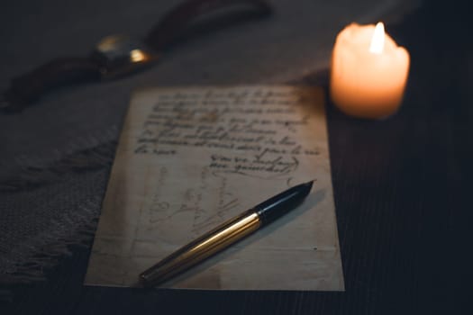 An antique letter with a gold pen in the candlelight. High quality photo