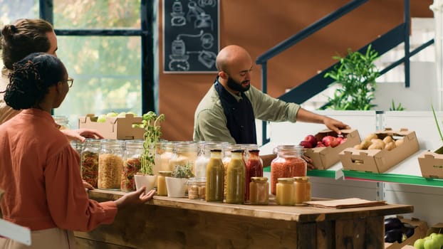 Couple shopping for organic produce in eco local supermarket, supporting small business owner and farmer. People looking to buy chemicals and additives free food or pantry supplies, vegan life.