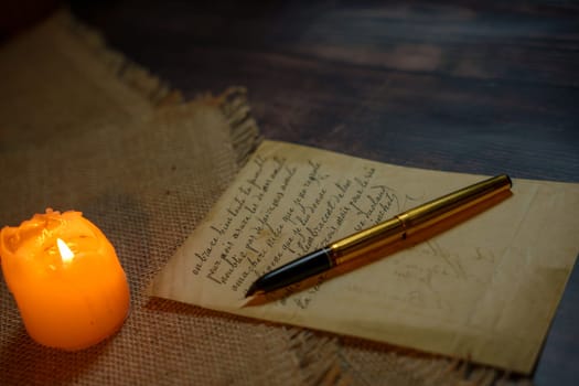 An antique letter with a gold pen in the candlelight. High quality photo