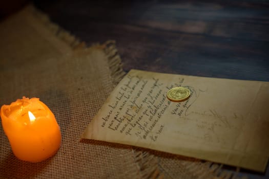 An antique letter with a coin in the light of a burning candle. High quality photo
