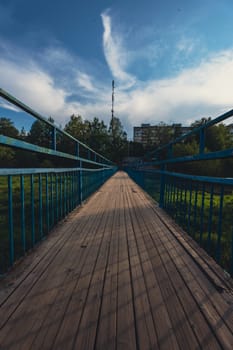 A wooden bridge across the river shot using an ultra-wide angle lens. High quality photo