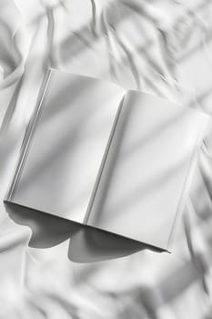 A book with triangle pattern cover lays open on a white cloth on a bed. The grey handwriting contrasts with the monochrome photography on the pages. Metal bookmark gleams in the light