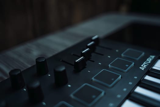 Black midi keyboard on a wooden table. Musical instrument. High quality photo