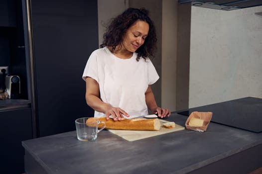 Woman cutting bread , preparing healthy sandwiches for breakfast in the home kitchen in the morning