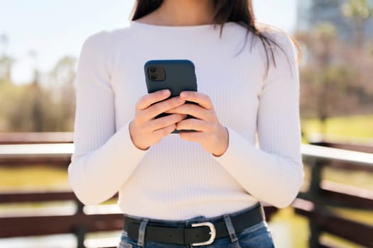 unrecognizable woman using mobile phone outdoors, concept of technology of communication and modern lifestyle