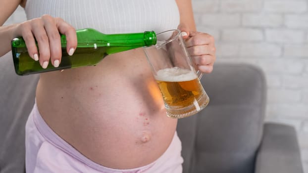 Faceless pregnant woman pouring beer into a glass