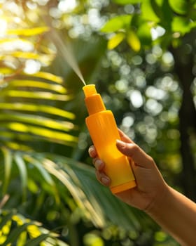 A hand holds a bright orange sunscreen spray bottle against a lush, green tropical backdrop with blurred palm leaves and sunlight filtering through