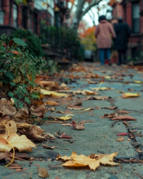 Fallen autumn leaves litter a charming cobblestone street, creating a serene and picturesque scene amidst the surrounding urban architecture