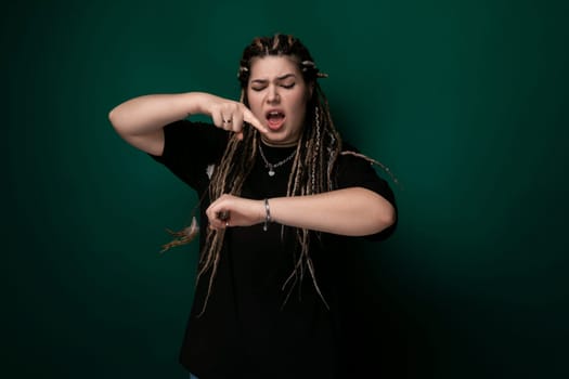 A woman with dreadlocks is striking a pose for a picture, showcasing her unique hairstyle. She exudes confidence while standing in front of the camera.