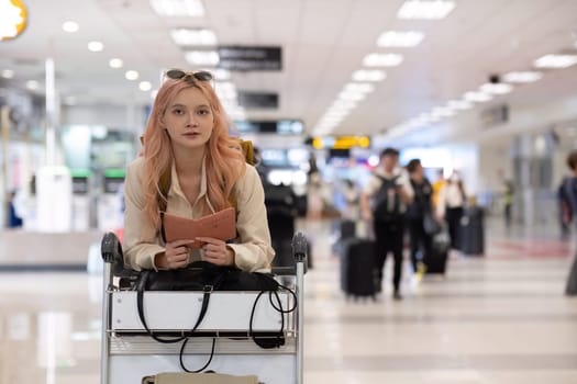 Woman holding passport in airport terminal. Concept of international travel and readiness.