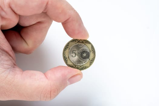 Holding new metal five turkish lira on white background