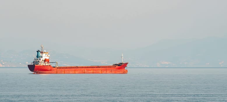 Orange general cargo ship anchored off the coast of Alanya, Antalya