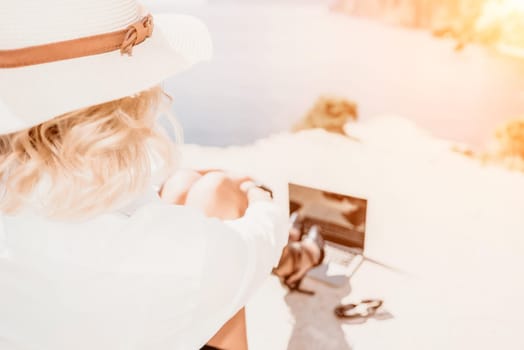 Happy girl doing yoga with laptop working at the beach. beautiful and calm business woman sitting with a laptop in a summer cafe in the lotus position meditating and relaxing. freelance girl remote work beach paradise