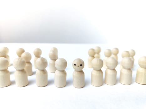 Wooden figurines with a leader and group with partial focus. The concept of distinguishing a leader from the crowd. Sighted, intelligent, different among the blind group