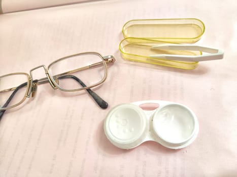 Set for contact lenses with a container, forceps, glasses. The concept of correcting myopia. Contact lens care, cleaning, health. Background, copy space