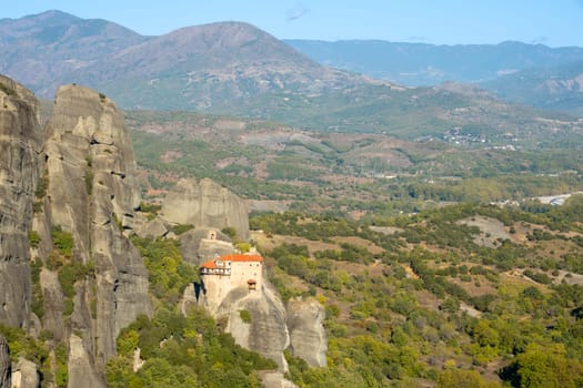 Greece. Sunny summer day in the Kalambaka valley. A small monastery with red roofs on a cliff