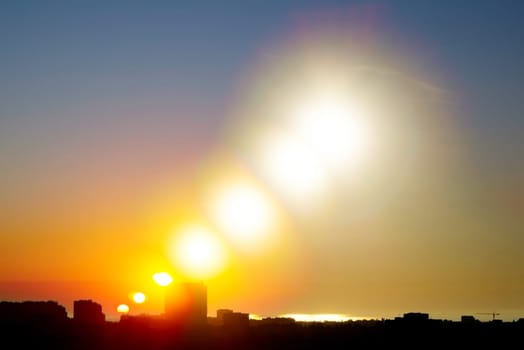 Ukraine. Sunrise in a clear sky over the coastal city of Odesa. Reflection in the sea. Multiple exposure