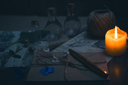 Mystical still life in vintage style with empty flasks, burning candles, letters and newspaper clippings. High quality photo