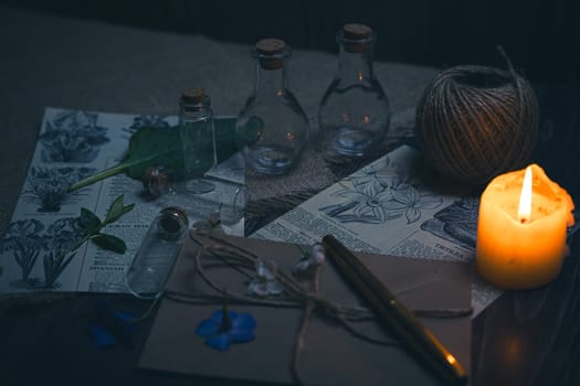 Mystical still life in vintage style with empty flasks, burning candles, letters and newspaper clippings. High quality photo