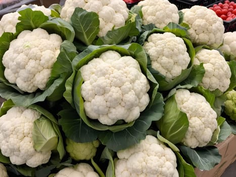 A vibrant display of fresh organic cauliflower at a local farmer's market, showcasing the natural beauty of the vegetable and the vibrant atmosphere of the market