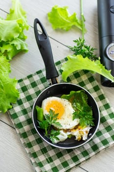 fried egg in a frying pan with herbs .