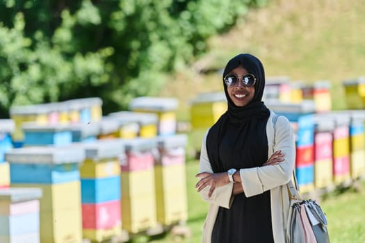 African American Muslim woman in hijab explores natural bee farms for honey production, blending tradition with sustainability in the serene countryside.