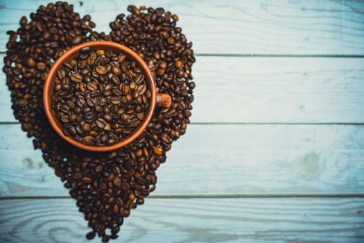 Coffee beans in a clay mug. A heart made of coffee beans. High quality photo