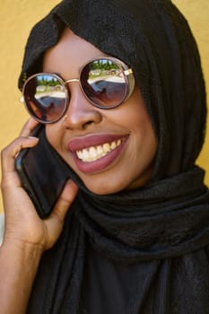 A close-up portrait captures the engagement of a Middle Eastern teenage Muslim girl in her digital world, as she uses a smartphone with focused attention