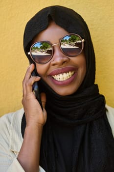 A close-up portrait captures the engagement of a Middle Eastern teenage Muslim girl in her digital world, as she uses a smartphone with focused attention