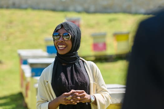 African American Muslim woman in hijab explores natural bee farms for honey production, blending tradition with sustainability in the serene countryside.