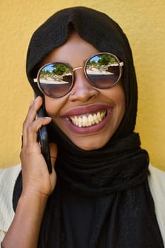 A close-up portrait captures the engagement of a Middle Eastern teenage Muslim girl in her digital world, as she uses a smartphone with focused attention