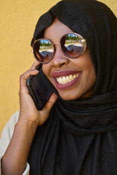 A close-up portrait captures the engagement of a Middle Eastern teenage Muslim girl in her digital world, as she uses a smartphone with focused attention