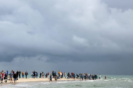 People walking along the seashore at cape Grene, Skagen Odde, Denmark - August 29, 2023.