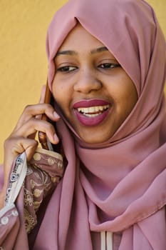 A close-up portrait captures the engagement of a Middle Eastern teenage Muslim girl in her digital world, as she uses a smartphone with focused attention