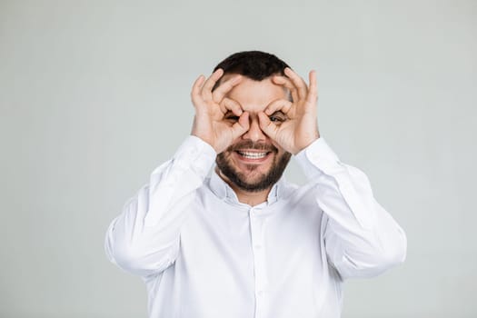 portrait of funny bearded man fooling around on gray background.