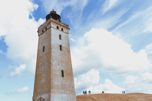 Rubjerg Knude Lighthouse on the coast of the North Sea in the Jutland in northern Denmark. Natural landscape with sand dunes. Rubjerg, Denmark - August 24, 2023.