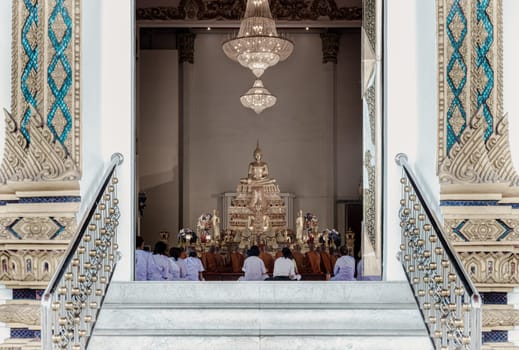 Bangkok, Thailand - May 22, 2024 - Thai women wear white clothes, doing the meditation. Buddha Monks are praying inside the monastery at Samphanthawong Saram Worawihan temple (Wat Ko). Space for text, Selective focus.