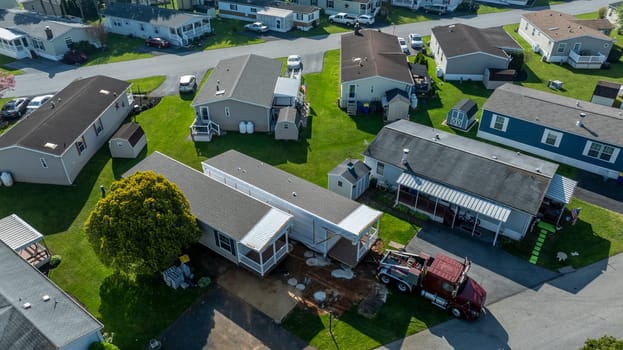 An Aerial View of a Manufactured, Mobile, Prefab Double Wide Home Being Installed in a Lot in a Park