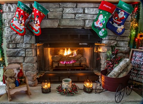 A fireplace with a red and green stocking hanging from it. The stocking is decorated with a santa and a snowman