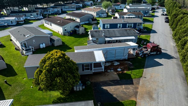 An Aerial View of a Manufactured, Mobile, Prefab Double Wide Home Being Installed in a Lot in a Park