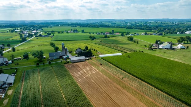 An Aerial View of Farmland with Crops, Barns, and Silos