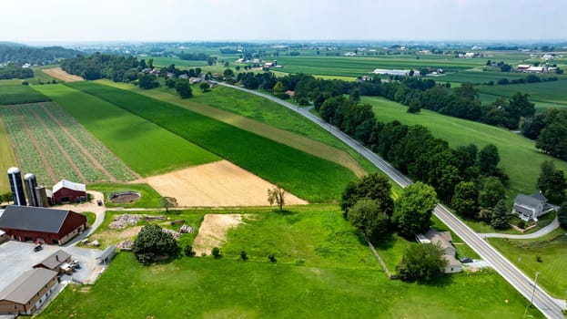 An Aerial View of Farmlands and Country Road in Rural Area