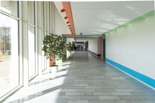 Long bright hall corridor with large windows and green plants in Herlev hospital. Copenhagen, Denmark - April 1, 2024.