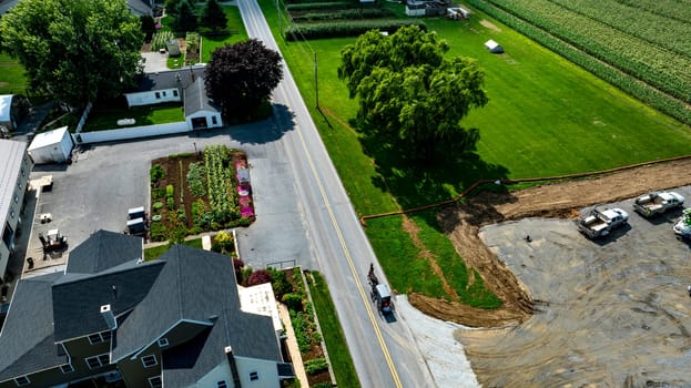 An Aerial View of Roadside Property with Garden and Construction Area and an Amish Horse and Buggy