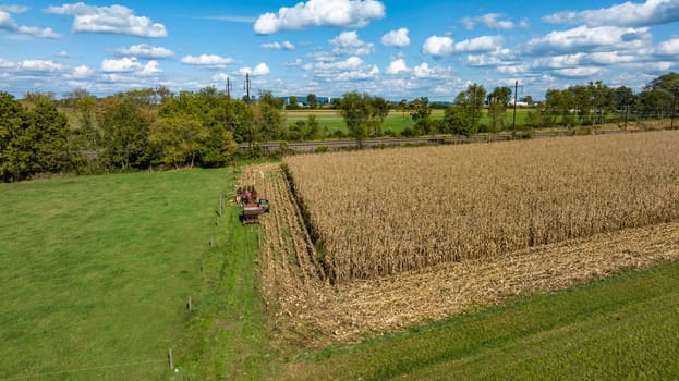 An Aerial View of Harvesting Corn with Tractors in Rural Field